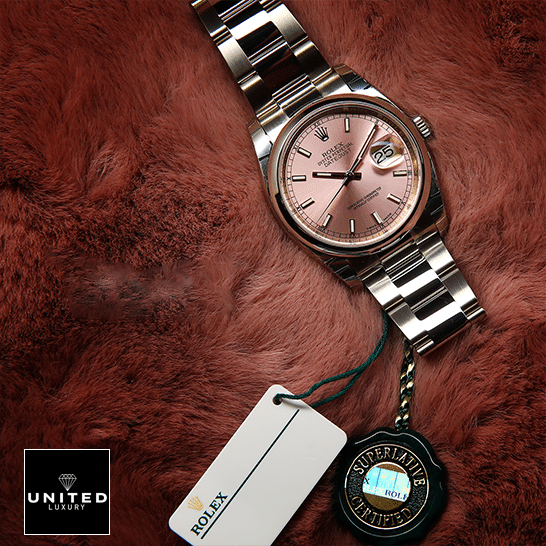 Rolex Datejust 116200 Pink Dial Replica next to the quarantine card on soft ground